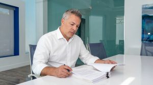Omid Khorshidi reviewing a personal injury case file at Khorshidi Law Firm in Beverly Hills, California.